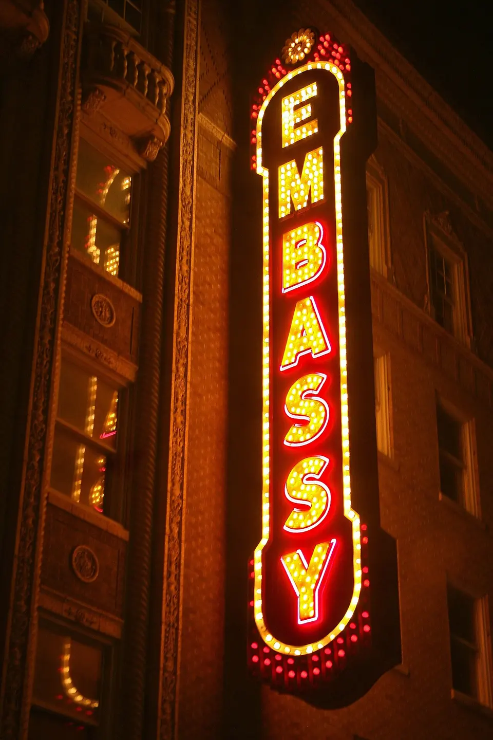 Illuminated vertical Embassy Theatre sign at night.