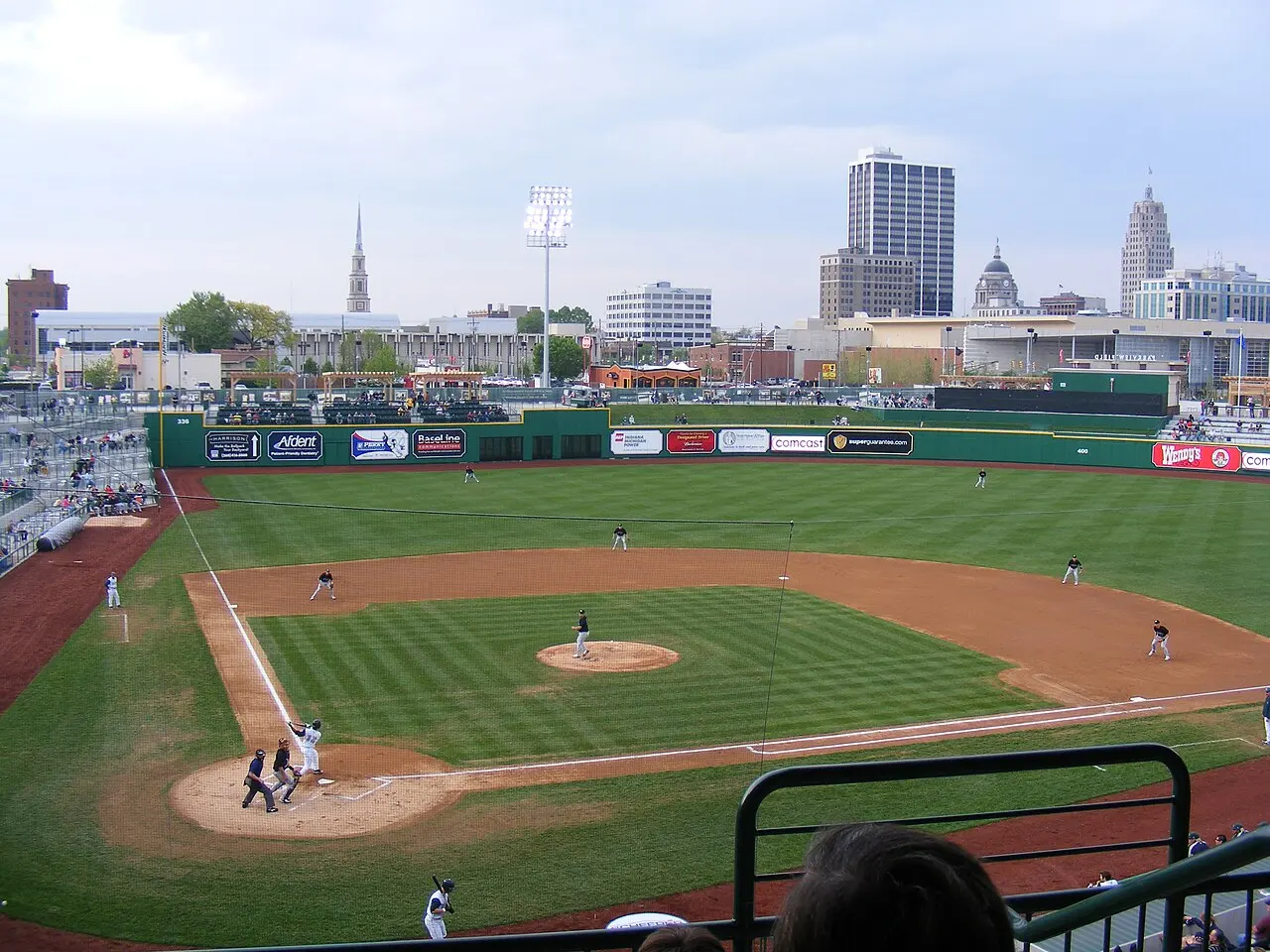 Baseball game at Parkview Field with the downtown Fort Wayne skyline beyond the outfield.